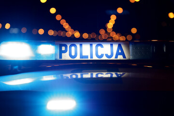 Nocna interwencja alarmowa policji - Sygnalizator błyskowy niebieski na dachu radiowozu policji polskiej w nocy. © FotoDax