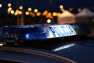 Fototapeta Nocna interwencja alarmowa policji - Sygnalizator błyskowy niebieski na dachu radiowozu policji polskiej w nocy. obraz