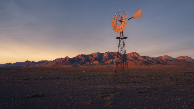 Windmill pumping water in rural outback landscape, Australia