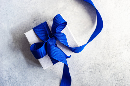 Overhead view of a gift box tied with a blue ribbon