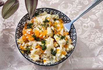 Vegetarian food: Pumpkin stew with rice in a bowl on the table. View from above.