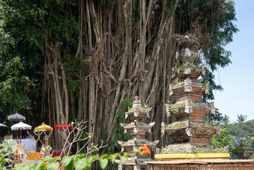 buddhist temple in the garden
banian tree
authentic sculptures Balinese gods creature religion 
hindu faith
Bali Indonesia
religion of Bali
creatures god of Bali