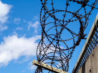 Illegal Immigrants and Refugee Transportation. Rusty barbed wire fence in sunny day