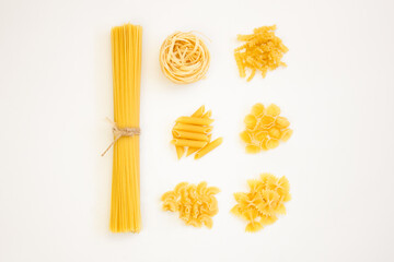 Different types of pasta on a white background, top view. Italian cuisine concept for food and menu styling.