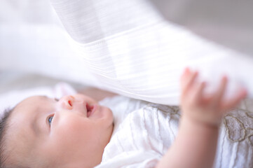 カーテンで遊ぶ赤ちゃん