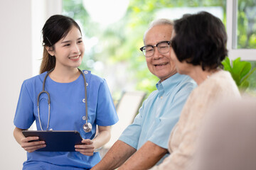 Asian woman doctor work in nursing home with digital tablet consults service to patient explains...