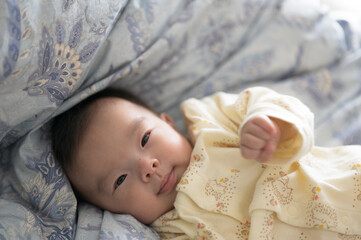 羽毛布団の上の赤ちゃん