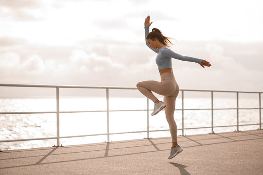 Young Energy Woman With Perfect Fit Body In Sports Clothing Jumping Outdoors. Side View.