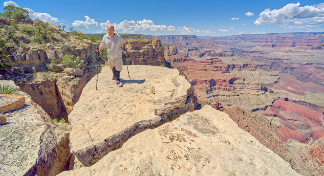 Hiker standing on a cliff between Moran Point and Zuni Point, Grand Canyon National Park, Arizona, USA