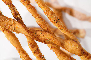 Grissini, bread sticks with Parmesan on a white background, close-up