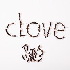 Clove spice seeds on white background as text, top view, square format