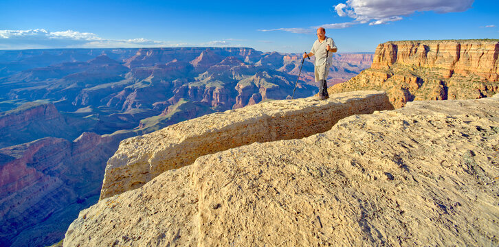 Hiker standing on a cliff between Moran Point and Zuni Point, Grand Canyon National Park, Arizona, USA