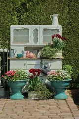 Foto op Plexiglas Garden corner. Spring blooming plant in green flower pots. © Weronika