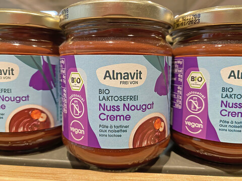 Viersen, Germany - June 9. 2022: Closeup of jars Alnavit organic lactose free hazelnut nougat spread in shelf of german supermarket