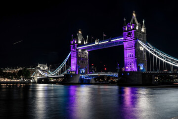 Fototapeta na wymiar Tower Bridge at night lit in purple honouring the Queen