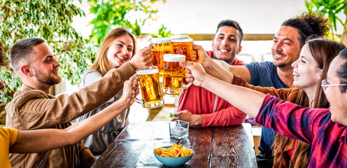 happy weekend. group of friends cheering clincking beer glasses in a pub restaurant celebrating...