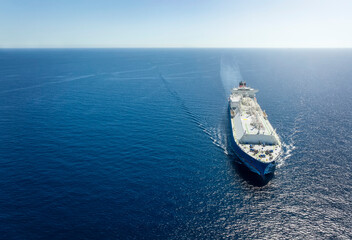 High aerial view of a large LNG or liquid gas tanker ship traveling over blue ocean, with copy space