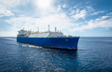 Front view of a large LNG or liquid gas tanker ship traveling with speed over blue ocean