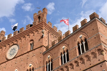 Fassade des Palazzo Pubblico mit Ziegelmauerwerk und spitzen Dreibogenfenstern
