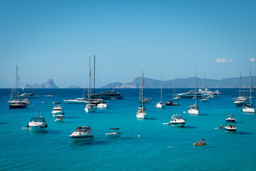Fototapeta na wymiar Boats anchored in Cala Saona with Es Vedra in the background