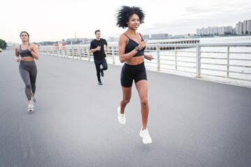 Sportswear and running shoes. A group of people are training runners fitness in the city.