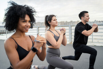 Use a fitness watch bracelet on the arm. A group of people are training running fitness in the city.