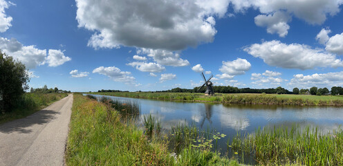 Panorama from a road and windmill next to a canal