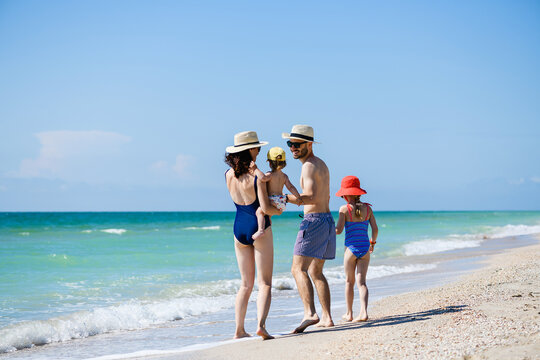 Happy young family walk at sea beach