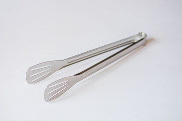 chromed kitchen tongs on an isolated white background