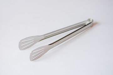 chromed kitchen tongs on an isolated white background