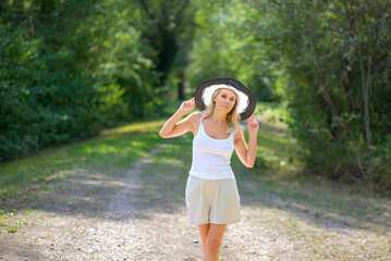 Obraz premium Blond woman wearing a black and white summer hat