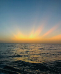 View from the bridge wings of a container ship at sea in the golden hour after sunset