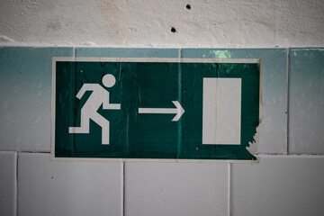 Exit sign during a fire with a graphic of a person and a ladder on the building wall