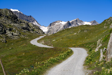 Fototapeta na wymiar Beautiful scenic view of Stone Glacier and gravel hiking trail in the foreground at Swiss mountain pass Sustenpass on a sunny summer day. Photo taken July 13th, 2022, Susten Pass, Switzerland.