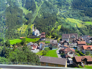 Beautiful scenic view of mountain village Wassen, Canton Uri, with catholic church on a sunny summer day. Photo taken July 13th, 2022, Wassen, Switzerland.