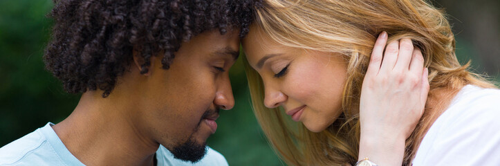  Portrait of young smiling mixed race couple in the summer nature