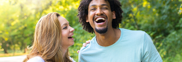 Portrait of young smiling mixed race couple in the summer nature