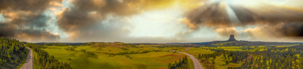 Panoramic aerial view of Devils Tower surrounding countryside at summer sunset, Wyoming