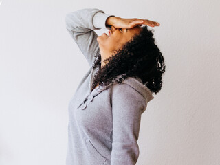 A young black African girl in grey hoody showing strong sad, frustrated emotion looking up and...