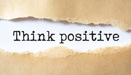 Think positive written under torn paper.