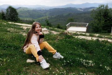 Tourist young girl child on the top of the Carpathian mountains Ukraine Bukovel. Vacation concept...
