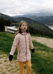 Tourist young girl child on the top of the Carpathian mountains Ukraine Bukovel. Vacation concept...