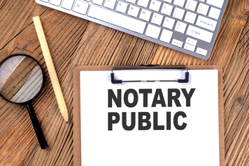 NOTARY PUBLIC text on paper clipboard with magnifier and keyboard on wooden background
