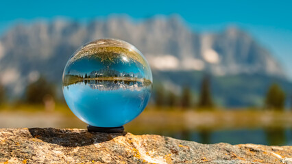 Crystal ball alpine landscape shot with reflections in a lake at the famous Astberg summit, Going, Wilder Kaiser, Tyrol, Austria