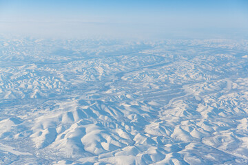 Aerial view of snow-capped mountains. Winter snowy mountain landscape. Kolyma Mountains, Magadan Region, Siberia, Far East of Russia. Great for backgrounds.
