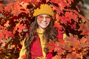 Teenager girl on autumn fall background. cheerful kid in sunglasses at autumn leaves on natural background