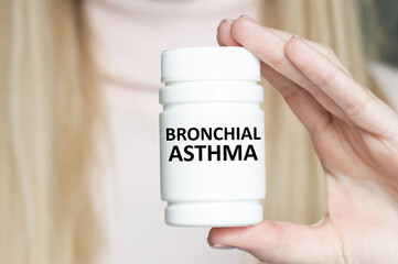 Doctor holding white jar labeled bronchial asthma, medical concept.