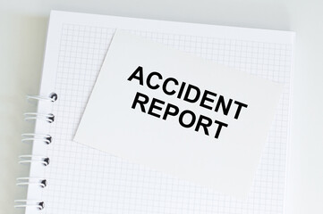 ACCIDENT REPORT text on a card on the background of a notebook on the table, business concept