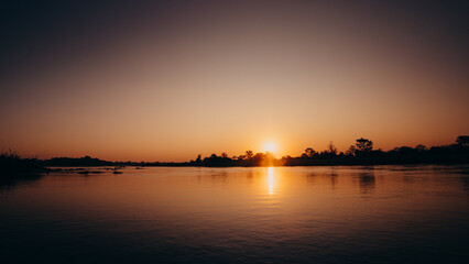 Fototapeta na wymiar Romantischer Sonnenuntergang am Okavango, Namibia