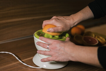 Squeezing orange juice with an orange juicer
